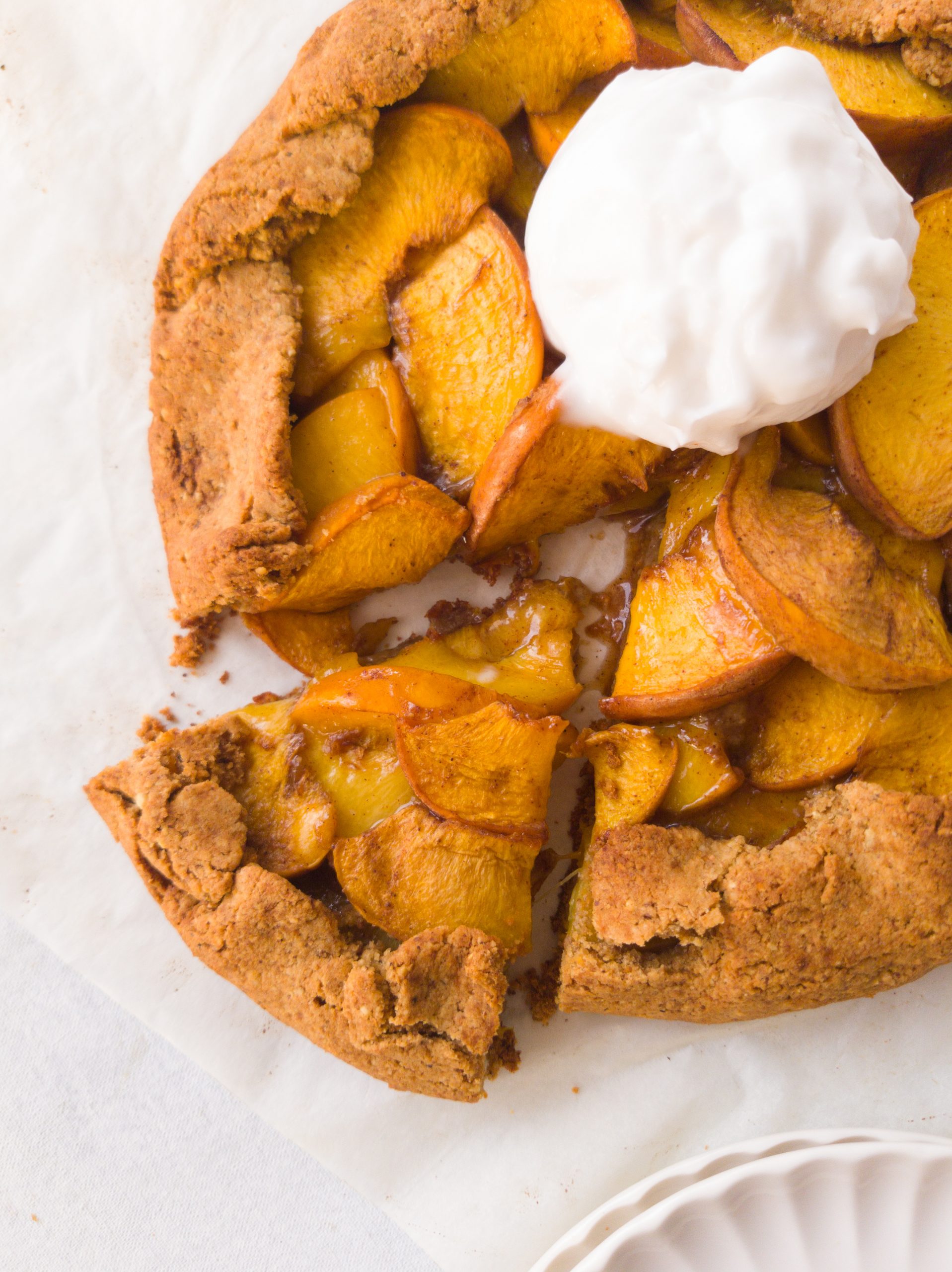 Galette con porción cortada con interior cremoso y bola de yogurt de coco servida como topping en una esquina de la galette
